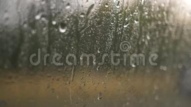 在夏季的阵雨中，玻璃上的水滴特写，大的雨滴撞击窗户玻璃。